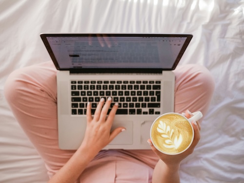girl seated with her laptop and coffee