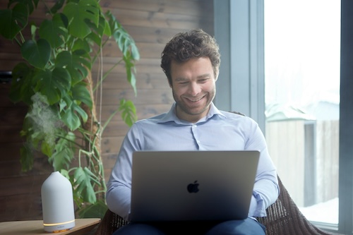 Man browsing on laptop smiling