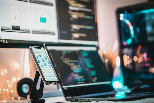 iphone laptop and desktop setup on a desk