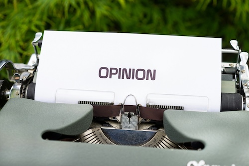 A typewriter with a paper that has 'opinion' written on it.